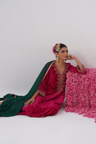 Rani Pink zardozi embroidered velvet kurta paired with red velvet pants and embroidered organza silk dupatta