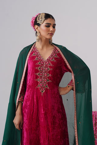 Rani Pink zardozi embroidered velvet kurta paired with red velvet pants and embroidered organza silk dupatta
