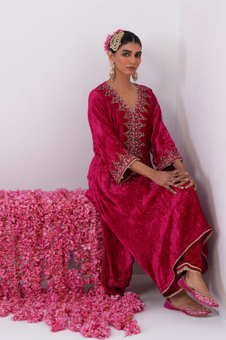 Rani Pink zardozi embroidered velvet kurta paired with red velvet pants and embroidered organza silk dupatta